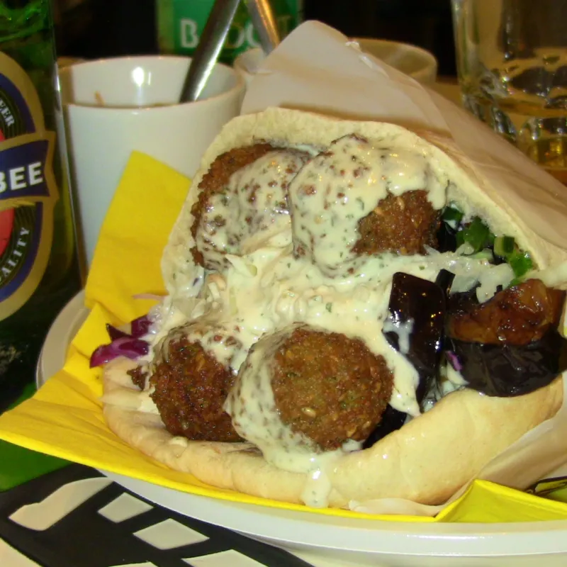 Pane pita con fallafel, salsa hummus, melanzane e birra